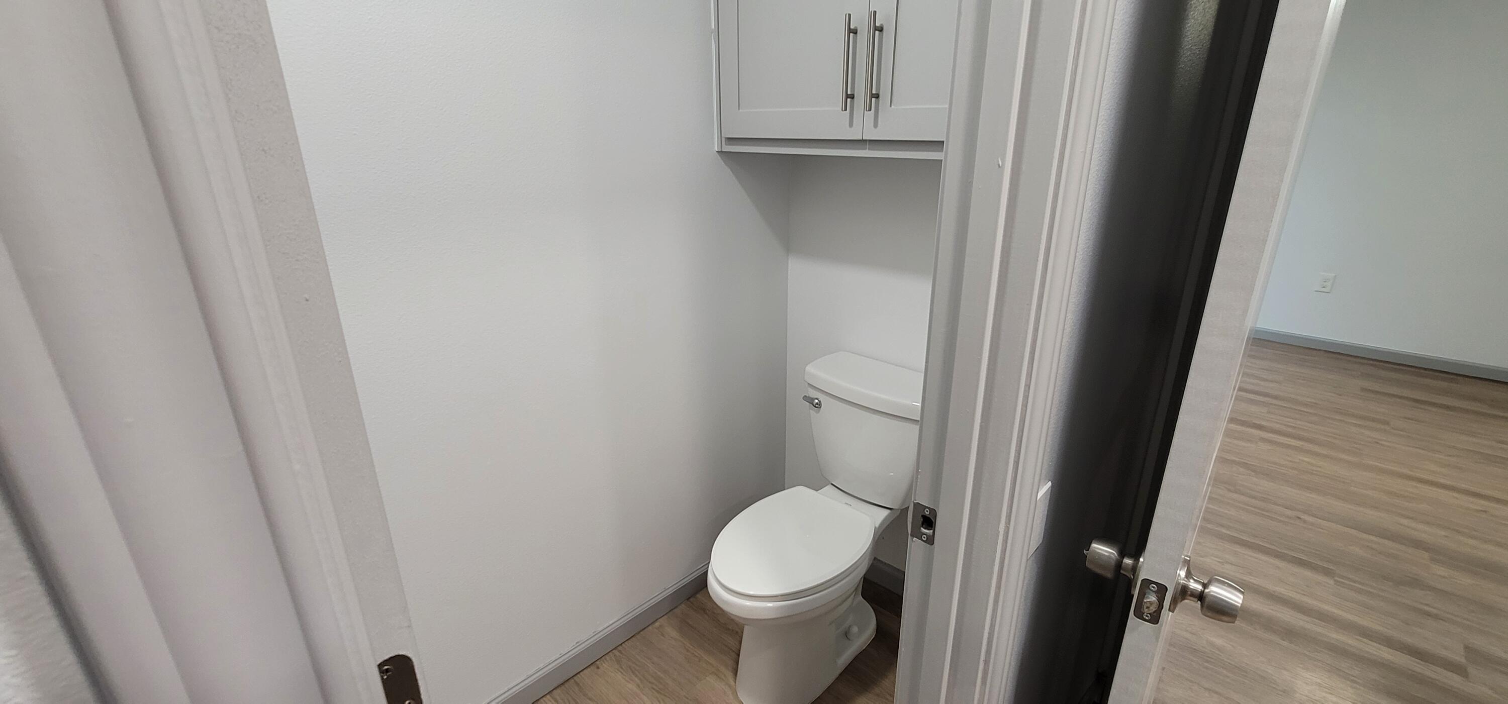 2110 88th Street Lubbock, TX 79423 - Photo 12 of 22 a white toilet sitting next to a white cabinet