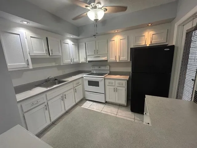a kitchen with a sink dishwasher a refrigerator and cabinets