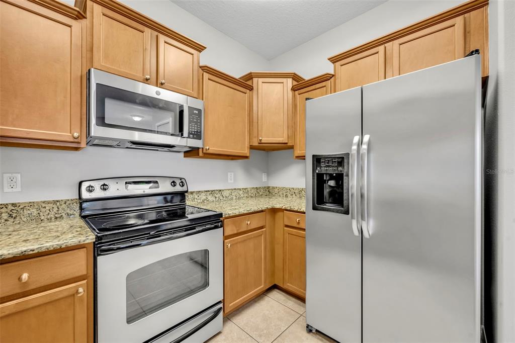 3201 Sonesta Court, Unit A Clermont, FL 34711 - Photo 12 of 34 a kitchen with stainless steel appliances granite countertop a refrigerator stove and microwave