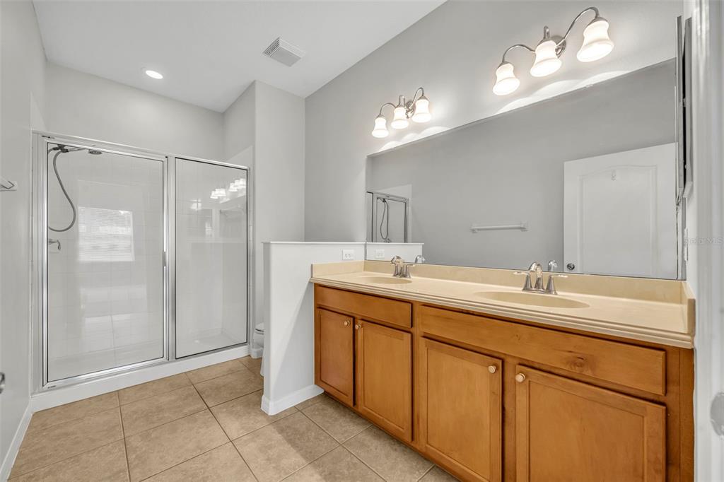 3201 Sonesta Court, Unit A Clermont, FL 34711 - Photo 24 of 34 a bathroom with a double vanity sink mirror and shower