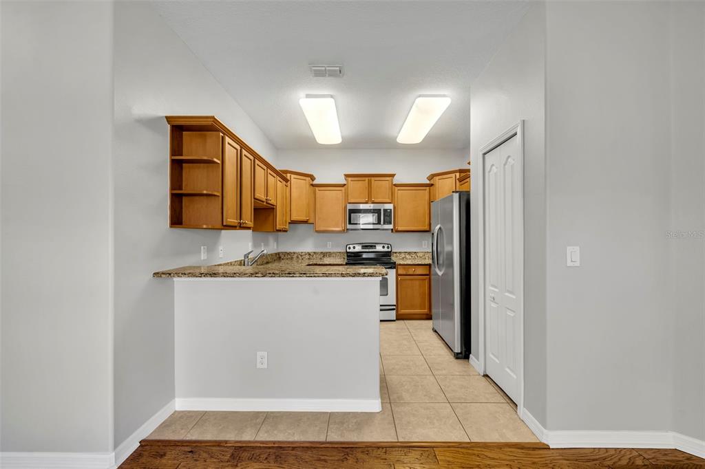 3201 Sonesta Court, Unit A Clermont, FL 34711 - Photo 9 of 34 a kitchen with stainless steel appliances granite countertop a refrigerator and a stove top oven