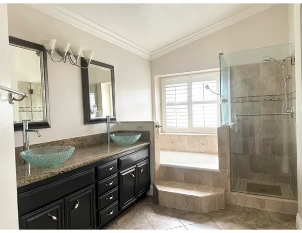 a bathroom with a granite countertop sink a mirror and a shower
