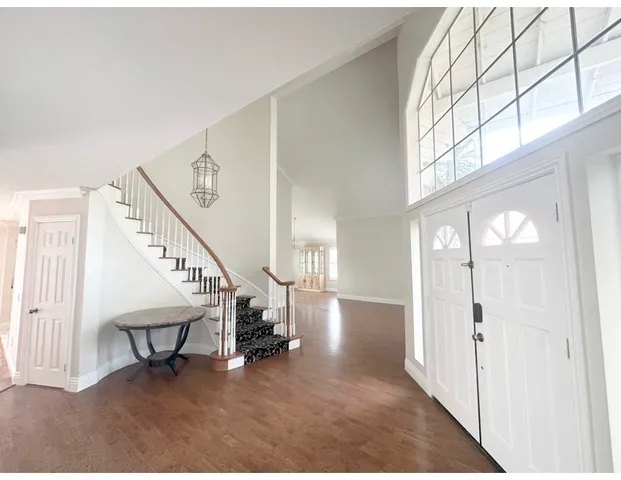 a view of a room with wooden floor and chandelier