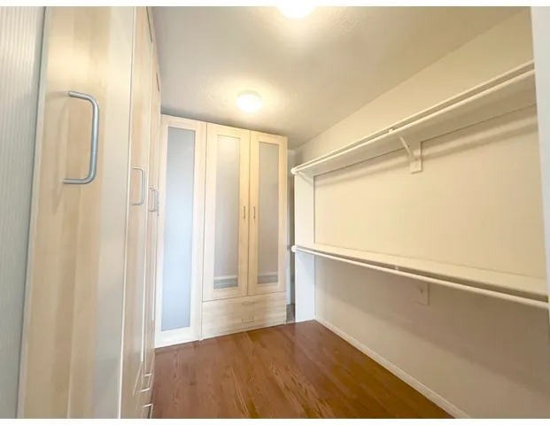 an empty room with windows and cabinet