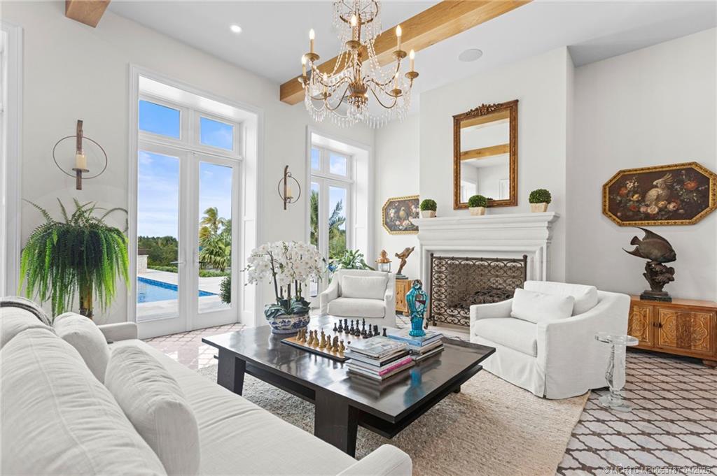 3 Island Road Sewall's Point, FL 34996 - Photo 11 of 59 a living room with furniture a chandelier and a fireplace