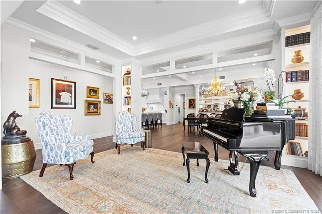 a view of a dining room and livingroom with furniture wooden floor a chandelier