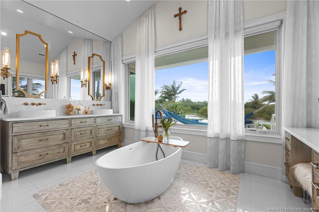 3 Island Road Sewall's Point, FL 34996 - Photo 28 of 59 a spacious bathroom with a tub sink and mirror