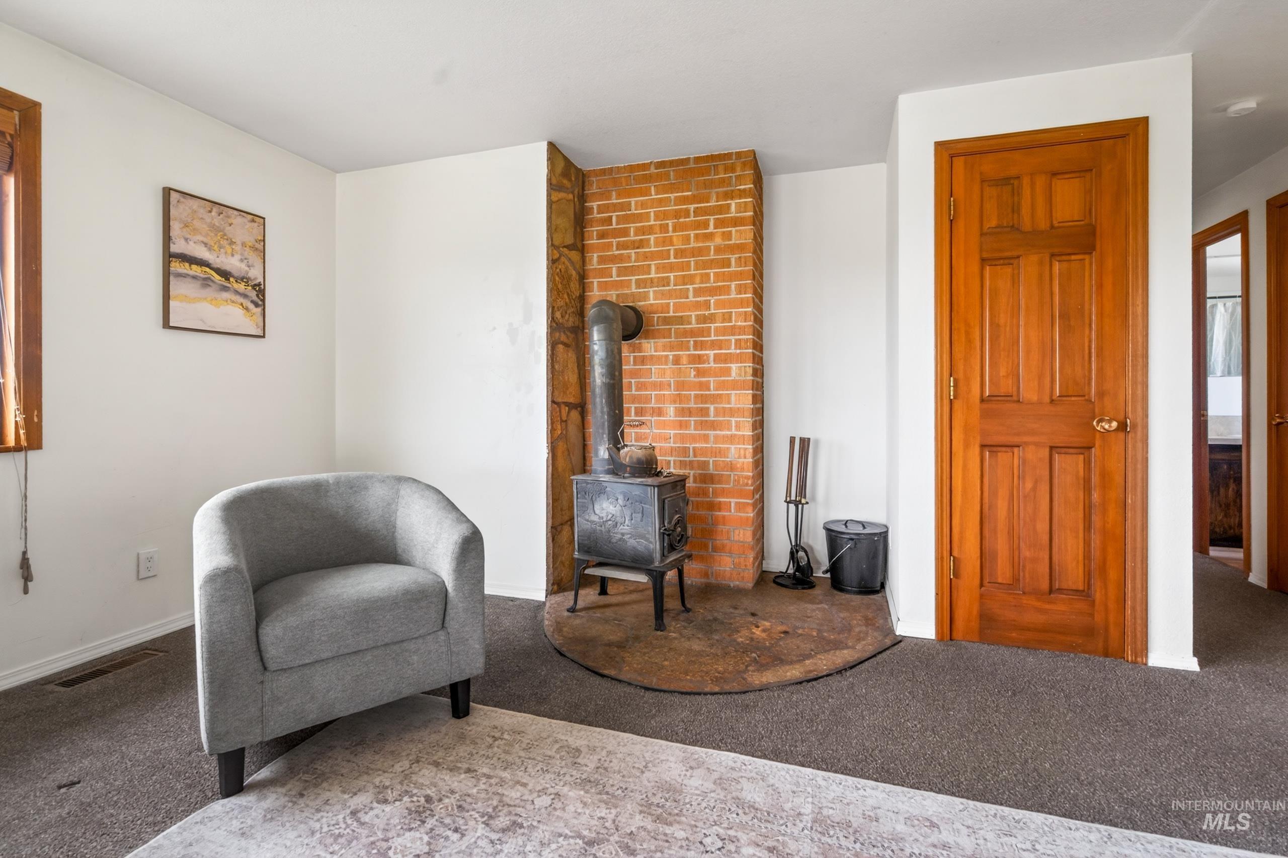 8989 Hillview Road Emmett, ID 83617 - Photo 17 of 50 Living area featuring a wood stove and carpet