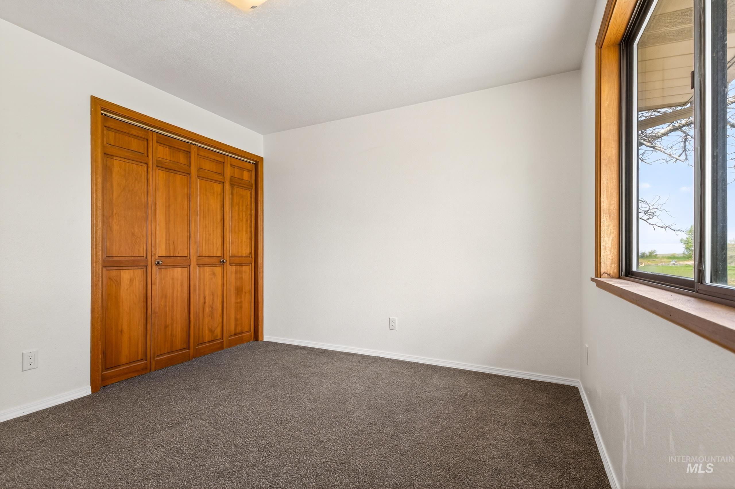 8989 Hillview Road Emmett, ID 83617 - Photo 27 of 50 Unfurnished bedroom featuring dark colored carpet and a closet