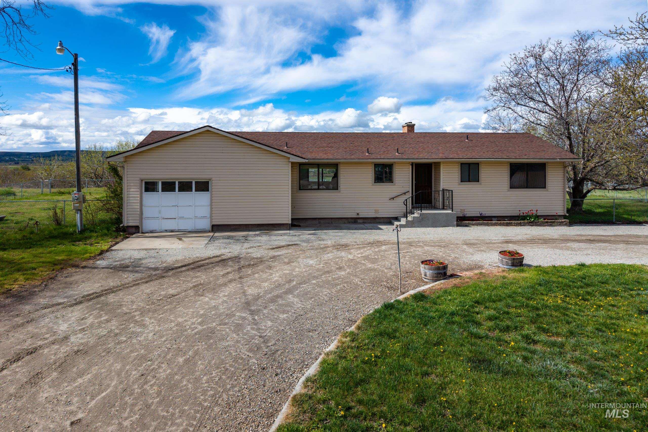 8989 Hillview Road Emmett, ID 83617 - Photo 3 of 50 Ranch-style home featuring dirt driveway, an attached garage, and a chimney