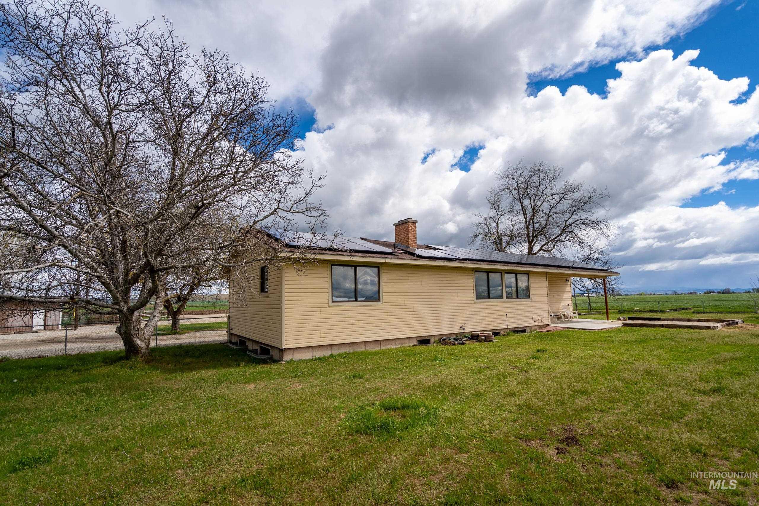 8989 Hillview Road Emmett, ID 83617 - Photo 46 of 50 View of side of property featuring solar panels, a chimney, a patio area, and a yard