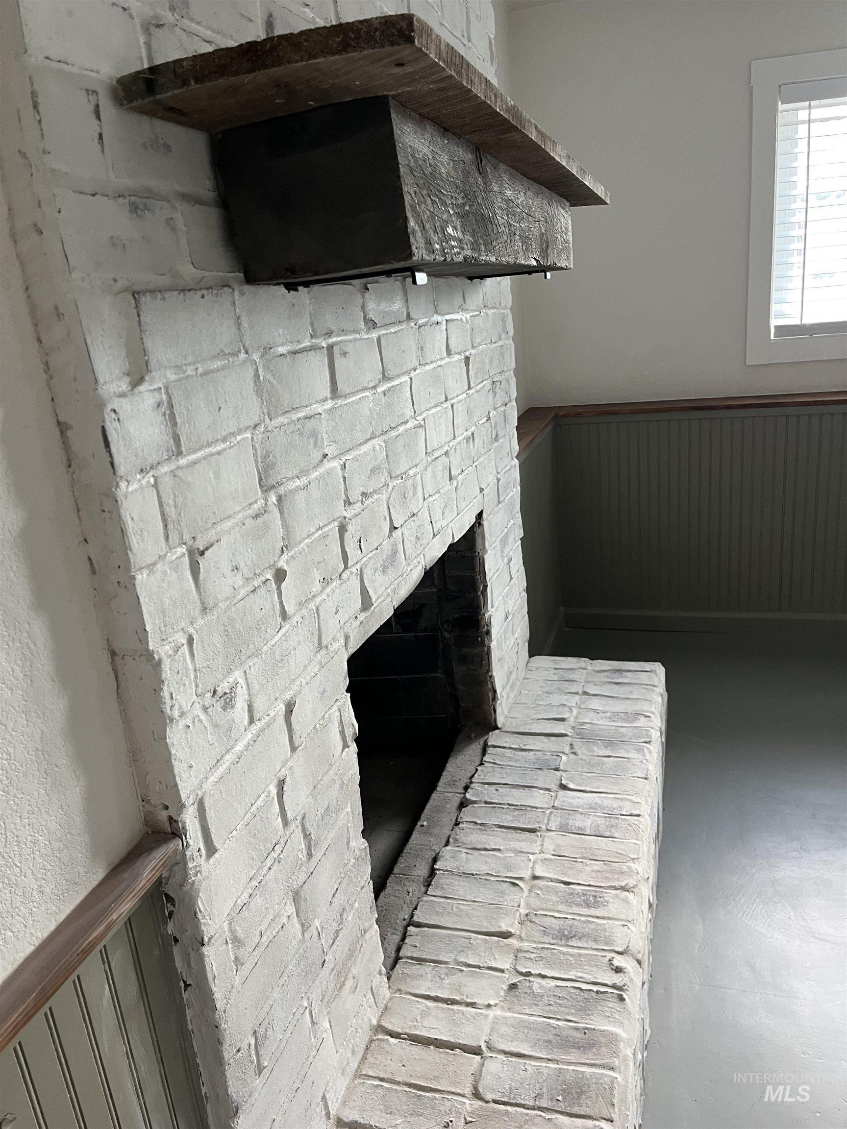 1024 El Cajon Street Moscow, ID 83843 - Photo 33 of 49 Detailed view of wainscoting, a brick fireplace, wood walls, and a decorative wall