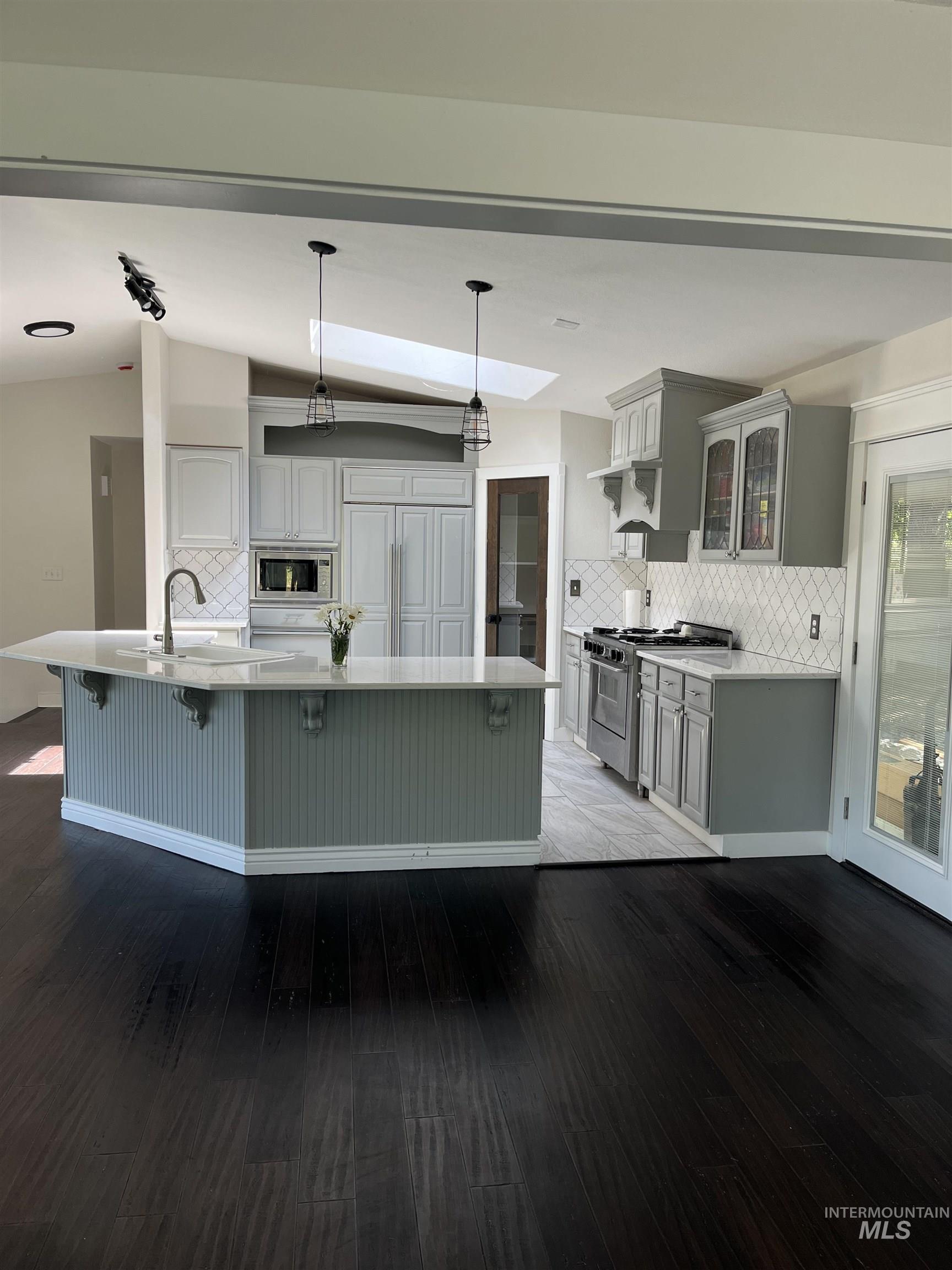 1024 El Cajon Street Moscow, ID 83843 - Photo 10 of 49 Kitchen with tasteful backsplash, vaulted ceiling, gray cabinets, and wood finished floors