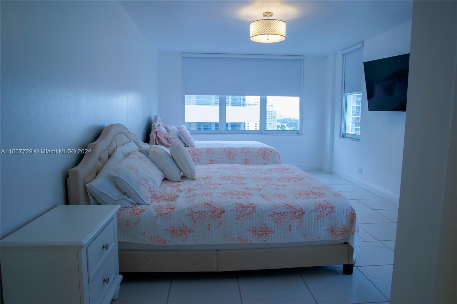 5601 Collins Avenue, Unit 1614 Miami Beach, FL 33140 - Photo 13 of 19 a bedroom with a bed and a flat screen tv