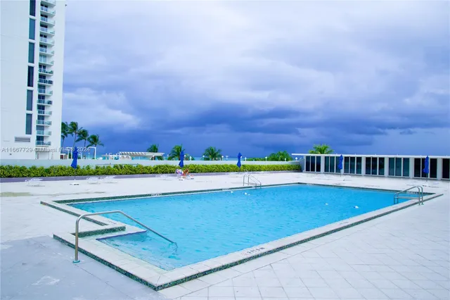 a view of swimming pool with outdoor seating and yard in back