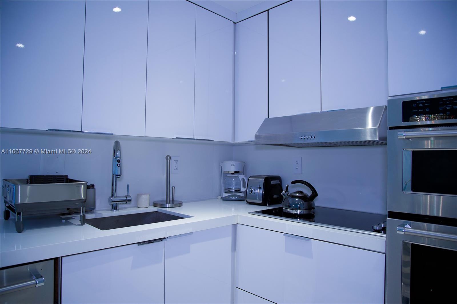 5601 Collins Avenue, Unit 1614 Miami Beach, FL 33140 - Photo 6 of 19 a kitchen with a sink cabinets and appliances