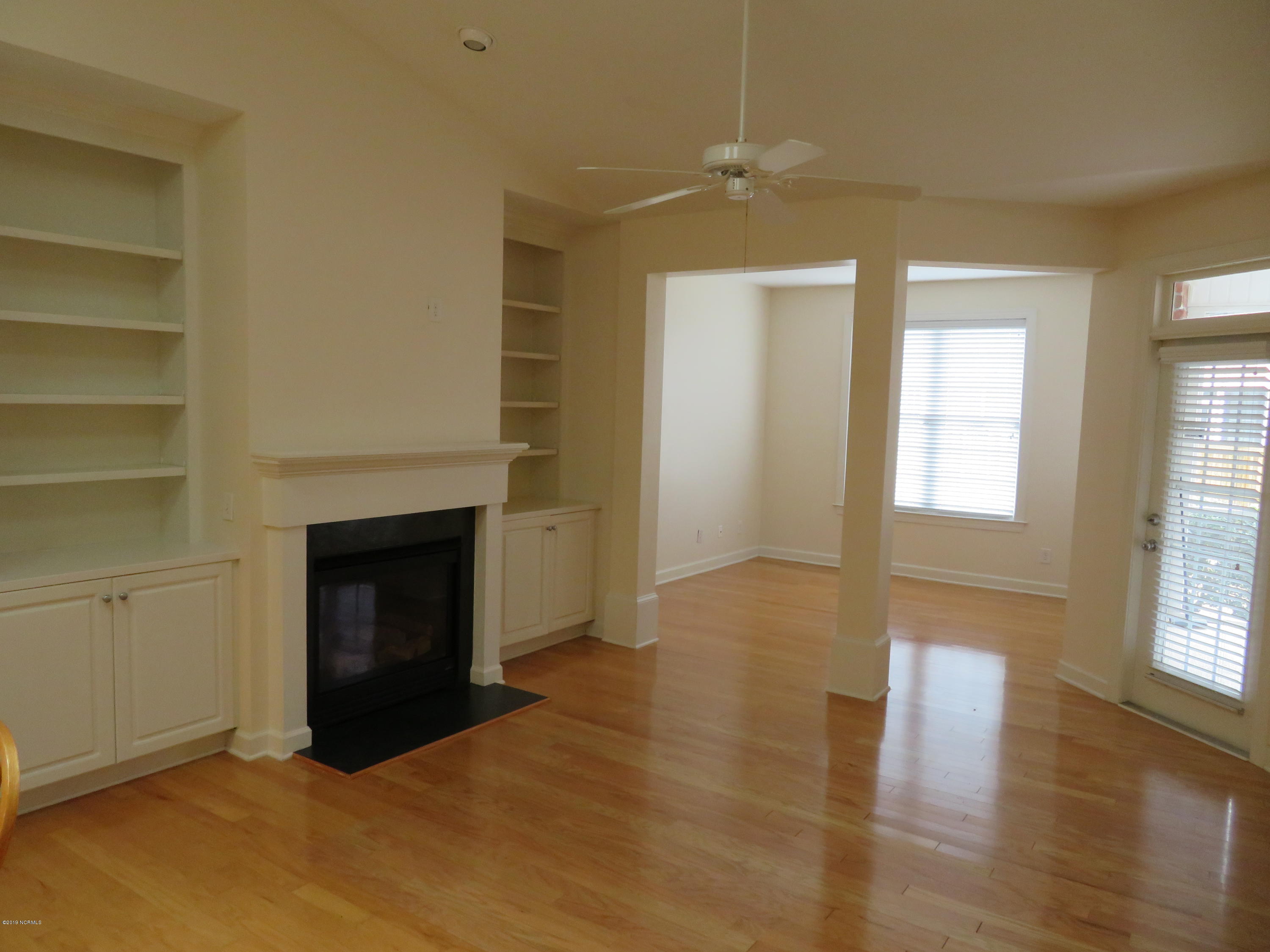 Charming Living Room with Fireplace, built in shelves and access to screened porch