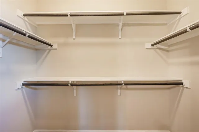 a bedroom with a bed and a flat tv screen on dresser