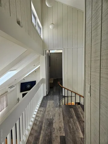 a view of a hallway with wooden floor and staircase