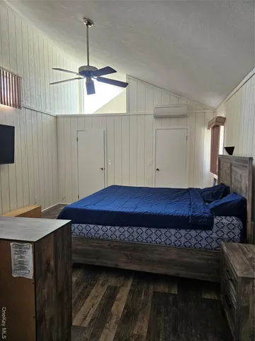 a view of a room with kitchen island stainless steel appliances wooden floor and window