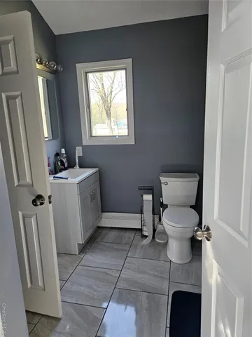 a bathroom with a toilet sink and mirror