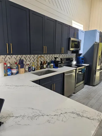 a kitchen with stainless steel appliances kitchen island granite countertop a sink stove and refrigerator