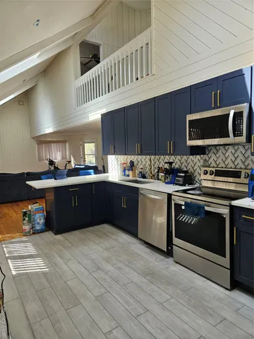 a kitchen with stainless steel appliances kitchen island granite countertop a stove a sink and a microwave