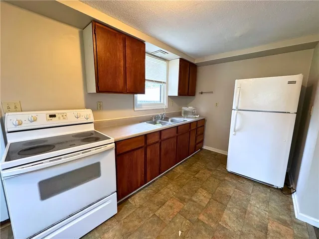 a kitchen with a refrigerator sink stove and cabinets