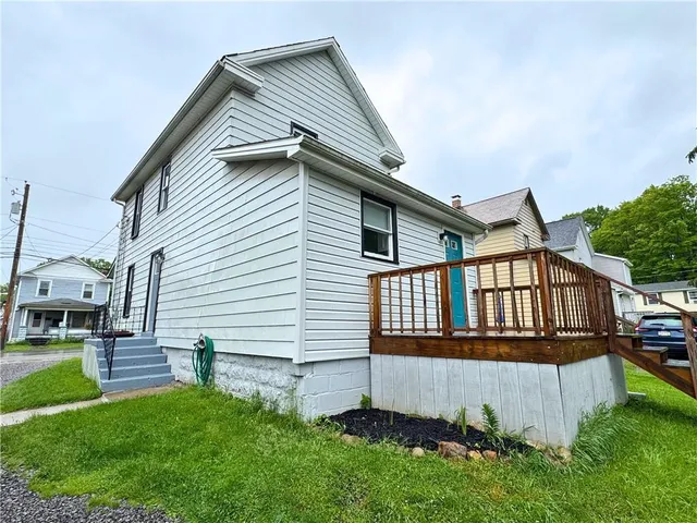 a front view of a house with a yard and deck