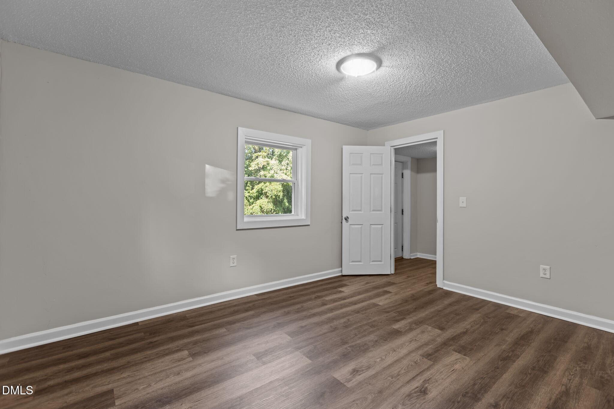 3117 Edgetone Drive Raleigh, NC 27604 - Photo 37 of 50 a view of an empty room with window and wooden floor