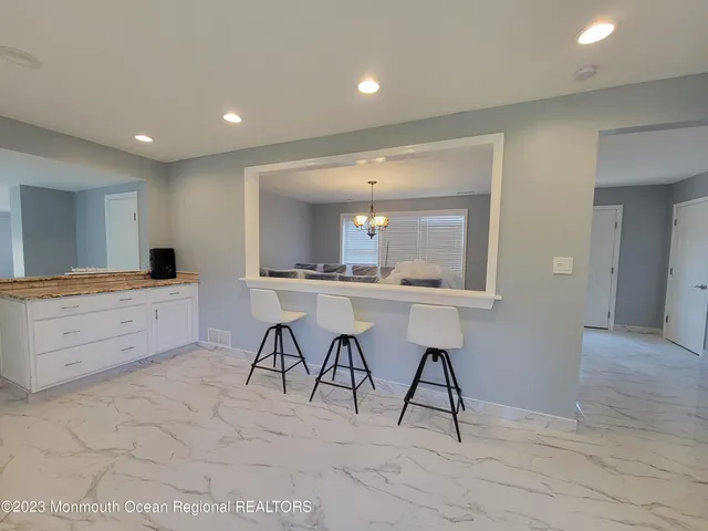 a large kitchen with kitchen island a counter top space a sink stainless steel appliances and cabinets