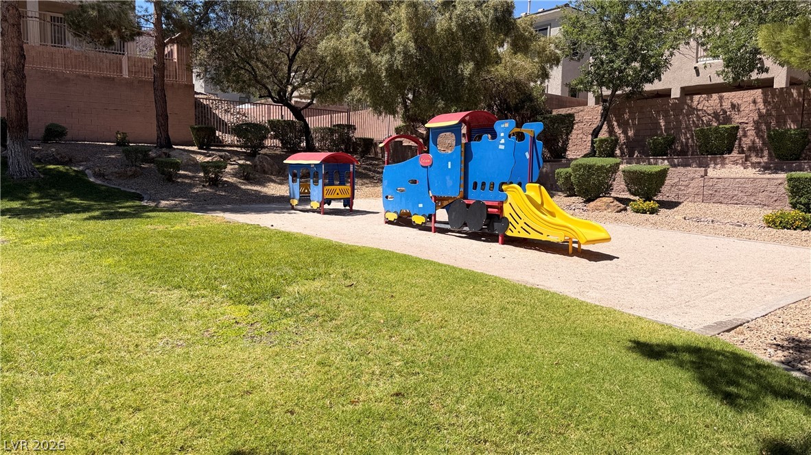 754 Solitude Point Avenue Henderson, NV 89012 - Photo 9 of 38 A vibrant train-themed play structure awaits, nestled in a community park with mature landscaping.