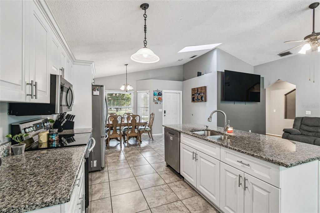 7501 Fawn Lake Road New Port Richey, FL 34655 - Photo 11 of 27 a large kitchen with kitchen island granite countertop a large counter top space appliances and cabinets