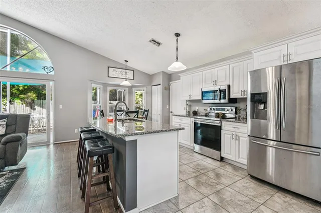 a large kitchen with stainless steel appliances granite countertop a stove oven and a sink with granite countertops