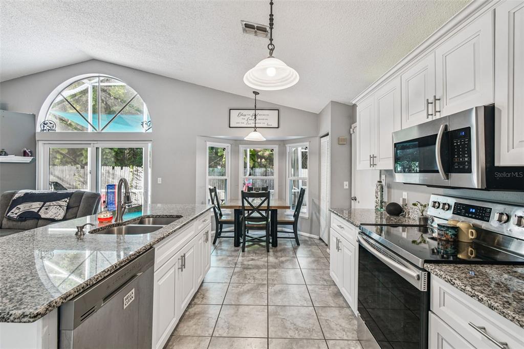 7501 Fawn Lake Road New Port Richey, FL 34655 - Photo 9 of 27 a large kitchen with stainless steel appliances granite countertop a stove oven and a sink with granite countertops