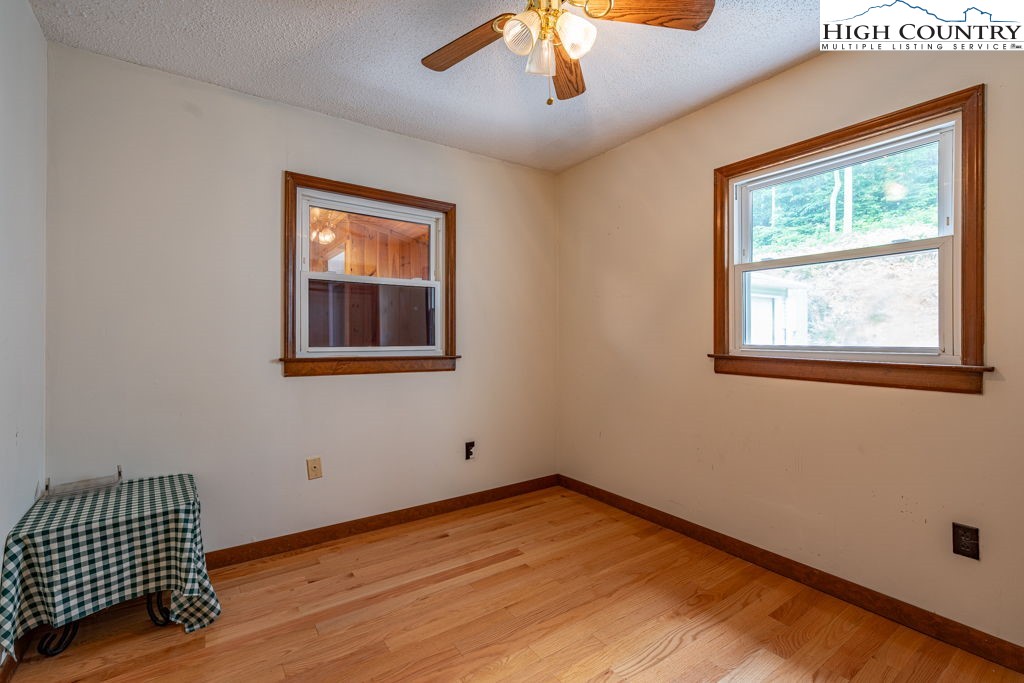 175 Roaring Fork Road Todd, NC 28684 - Photo 12 of 24 a view of an empty room with wooden floor and a window
