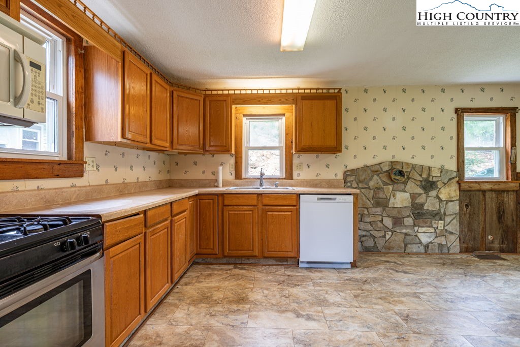 175 Roaring Fork Road Todd, NC 28684 - Photo 7 of 24 a kitchen with stainless steel appliances granite countertop a stove a sink and a microwave