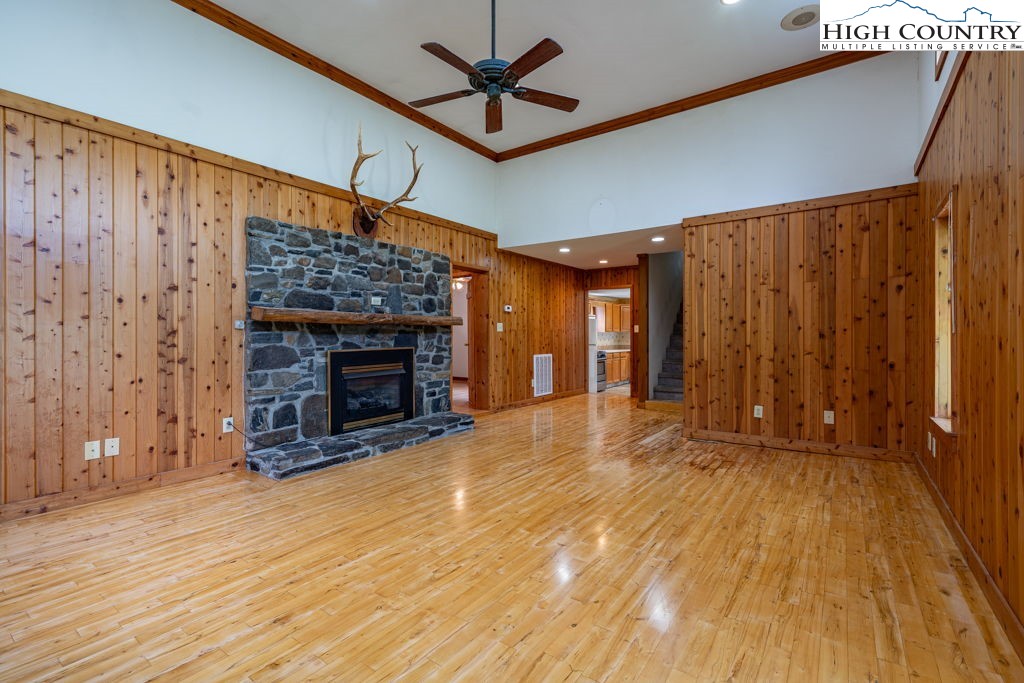 175 Roaring Fork Road Todd, NC 28684 - Photo 10 of 24 a view of an empty room with wooden floor and a fireplace