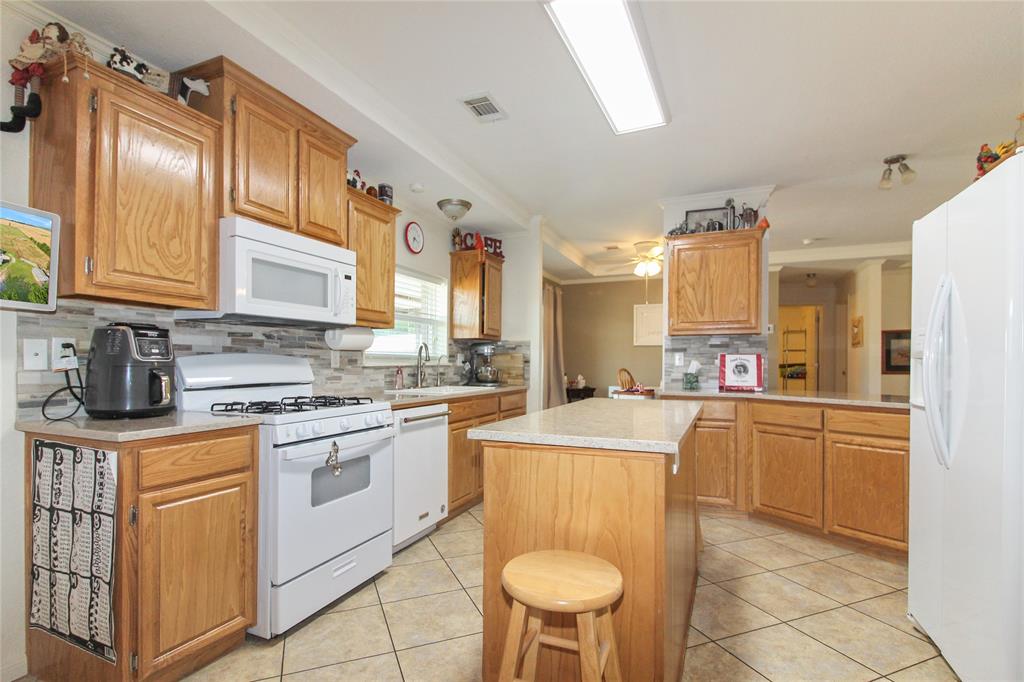 455 Hughes Cemetery Road Italy, TX 76651 - Photo 11 of 40 a kitchen with stainless steel appliances granite countertop a stove a sink dishwasher and a refrigerator