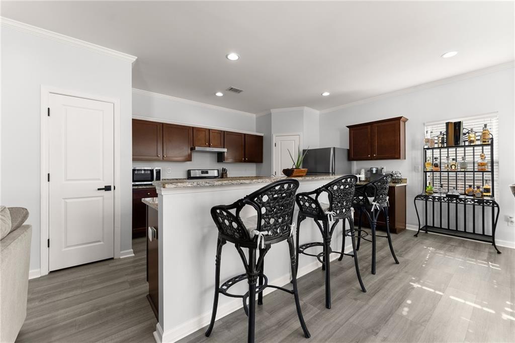 4302 Box Elder Path Gainesville, GA 30504 - Photo 13 of 53 a kitchen with stainless steel appliances a table chairs refrigerator and a sink