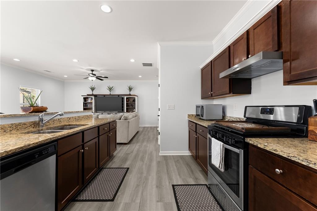4302 Box Elder Path Gainesville, GA 30504 - Photo 14 of 53 a large kitchen with stainless steel appliances granite countertop a stove and a sink