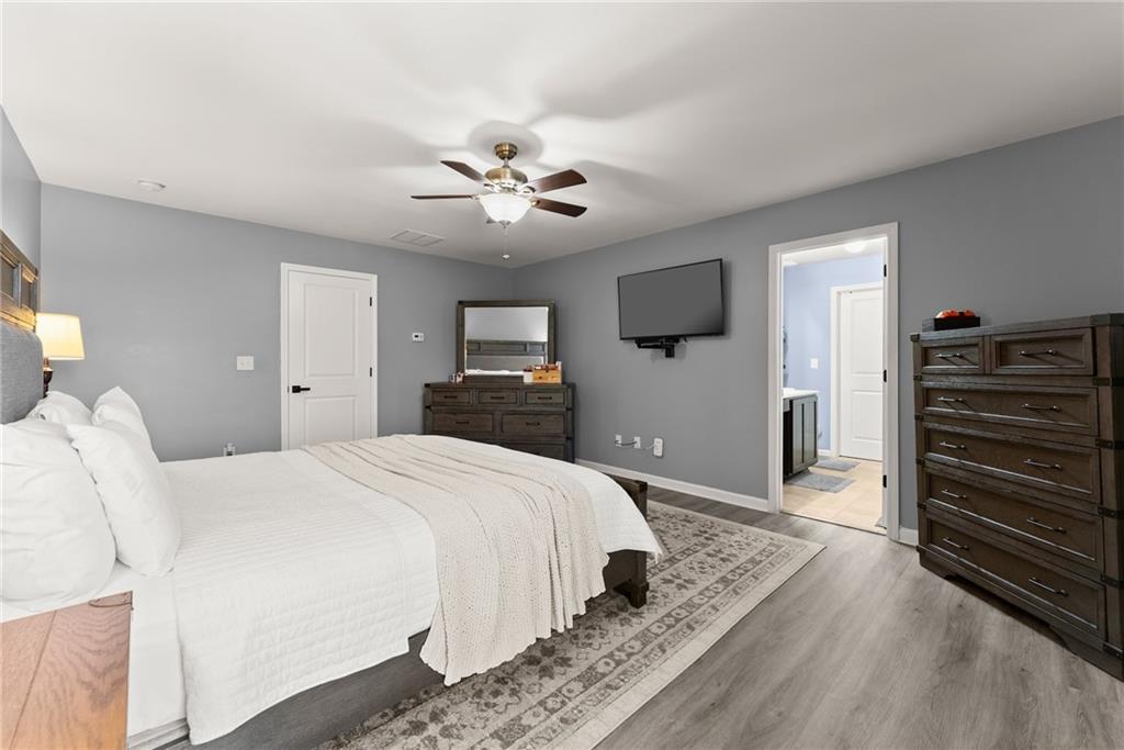 4302 Box Elder Path Gainesville, GA 30504 - Photo 19 of 53 a spacious bedroom with a bed and a chandelier