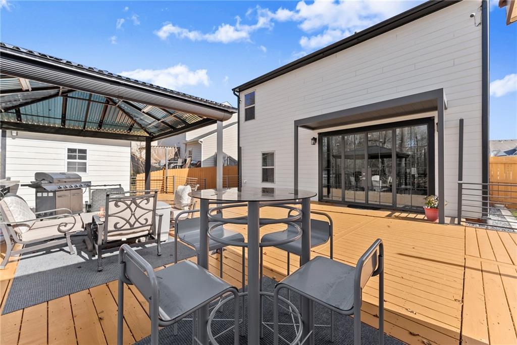4302 Box Elder Path Gainesville, GA 30504 - Photo 37 of 53 a view of a patio with table and chairs potted plants with wooden floor and fence