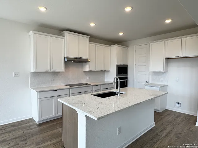 a kitchen that has a sink and a stove in it