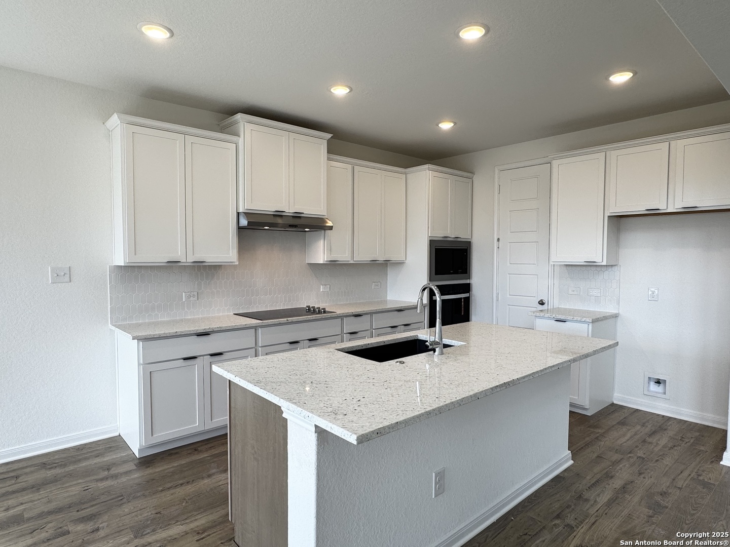 165 Annette Drive Castroville, TX 78009 - Photo 3 of 11 a kitchen that has a sink and a stove in it
