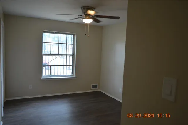 an empty room with a window and a fan