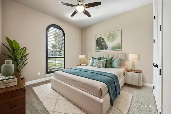 a bedroom with a large bed and a potted plant
