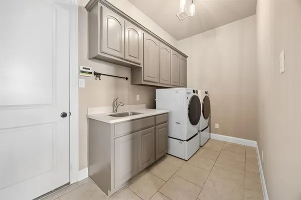 a utility room with cabinets washer and dryer