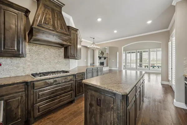 a kitchen with granite countertop a stove and a wooden floors