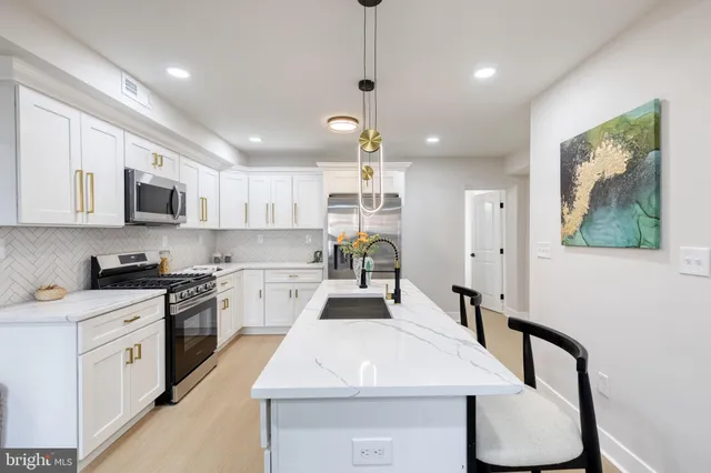 a kitchen with kitchen island a stove a table and chairs in it